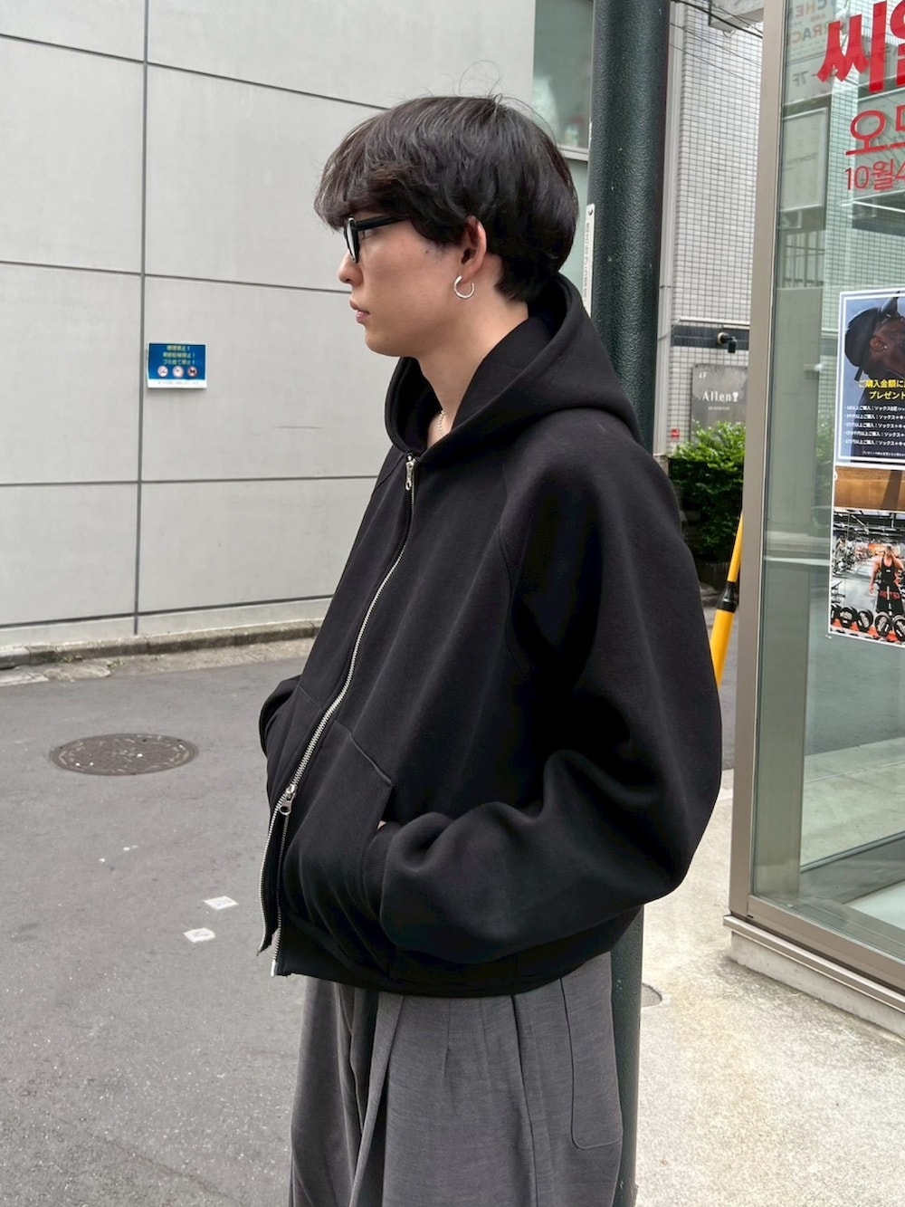 ブラック系のパーカー、グレー系のスラックスを着用したメンズの冬コーディネートの4枚目の写真