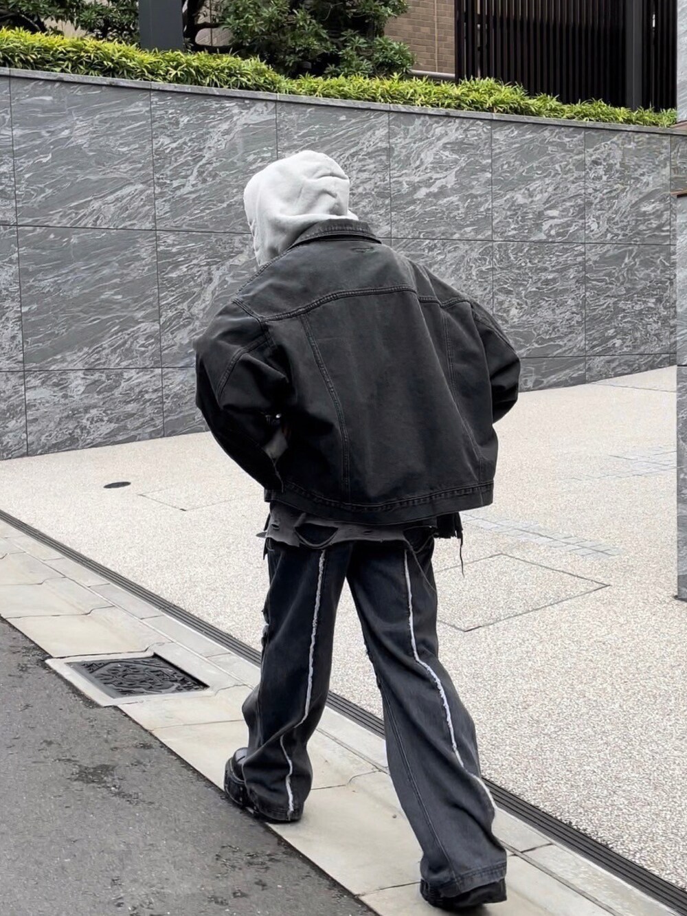 ブラック系のデニムジャケット、グレー系のパーカー、グリーン系のニットキャップ/ビーニーを着用したメンズの秋コーディネートの3枚目の写真