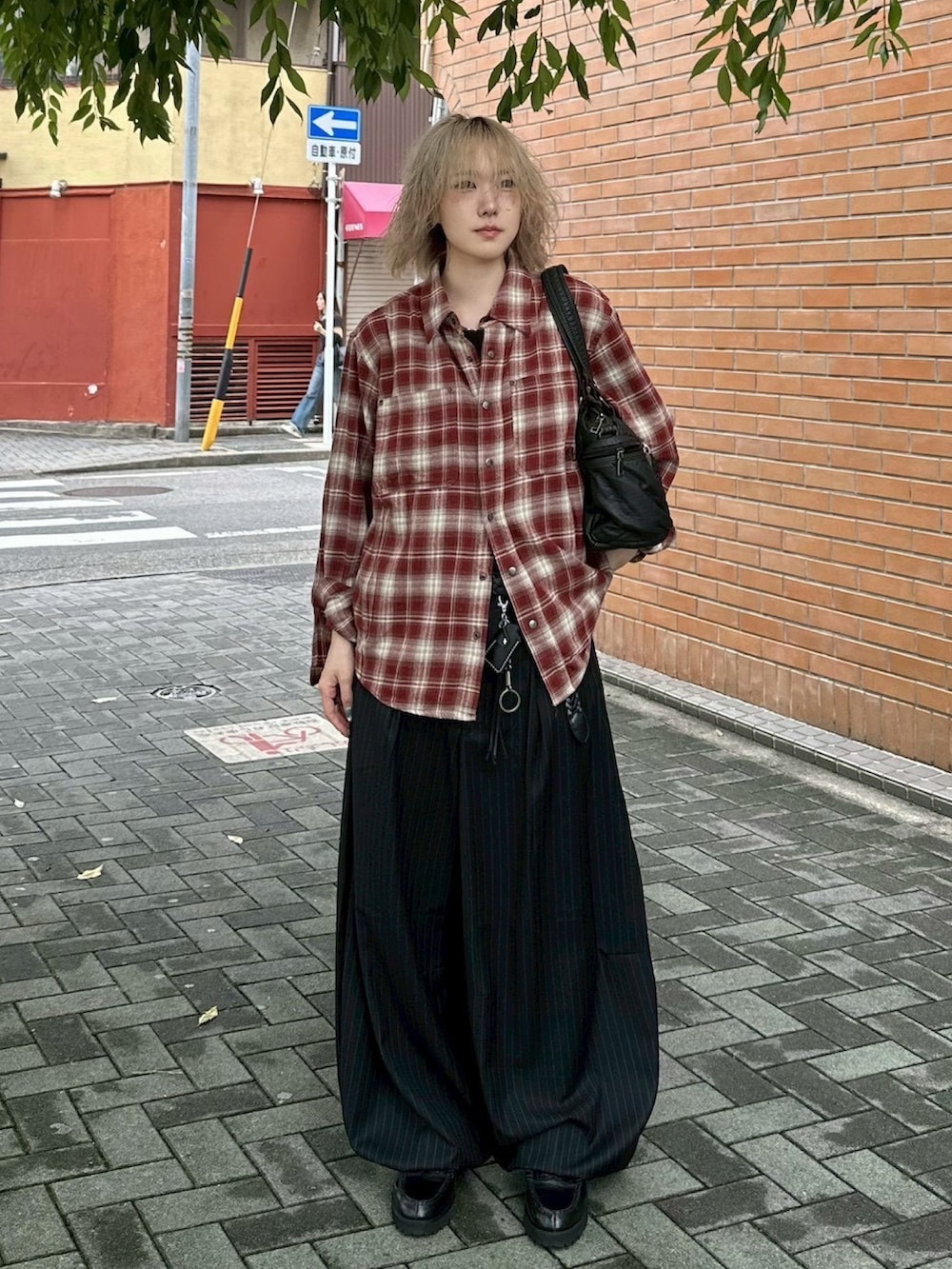 ブラック系のタンクトップ、ブラック系のトートバッグ、ブラック系のスラックスを着用したレディースの冬コーディネートの2枚目の写真