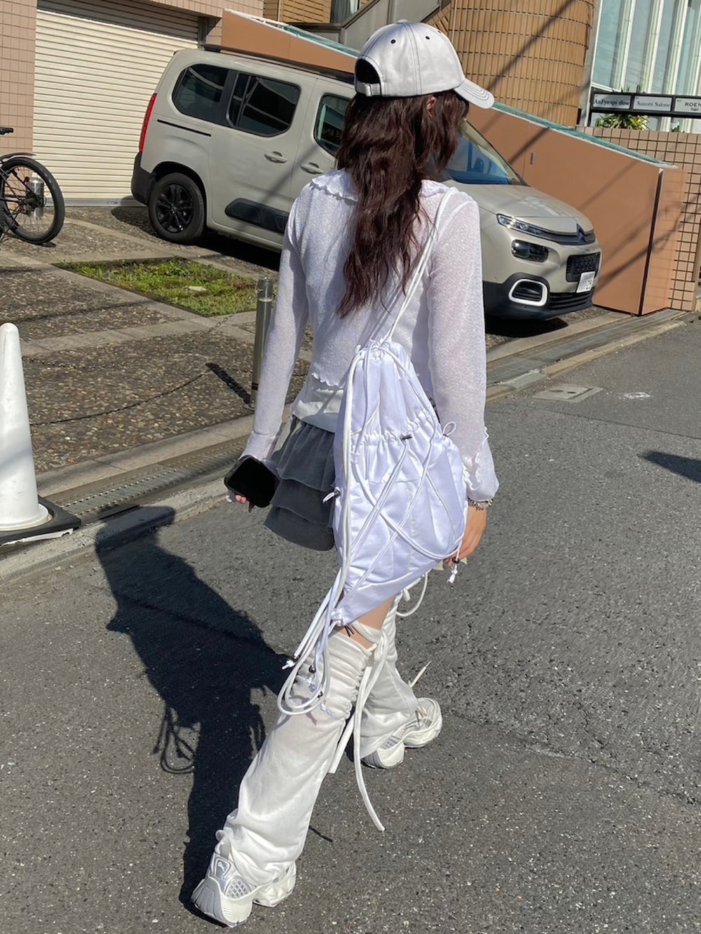 ホワイト系のタンクトップ、グレー系のスカート、ホワイト系のバックパック/リュックを着用したレディースの春コーディネートの2枚目の写真