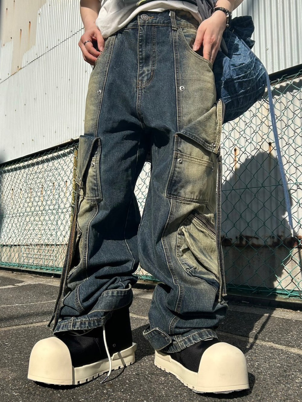 グレー系のパーカー、ブルー系のデニムパンツ、ブラック系のスニーカーを着用したレディースの春コーディネートの3枚目の写真