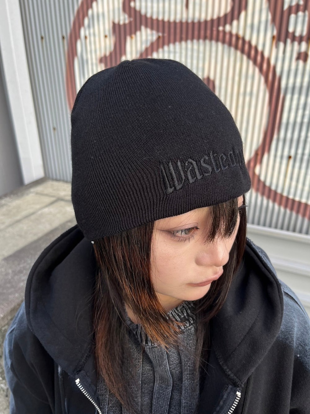 ブルー系のデニムパンツ、ブラック系のニット/セーター、ブラック系のパーカーを着用したレディースの秋コーディネートの3枚目の写真