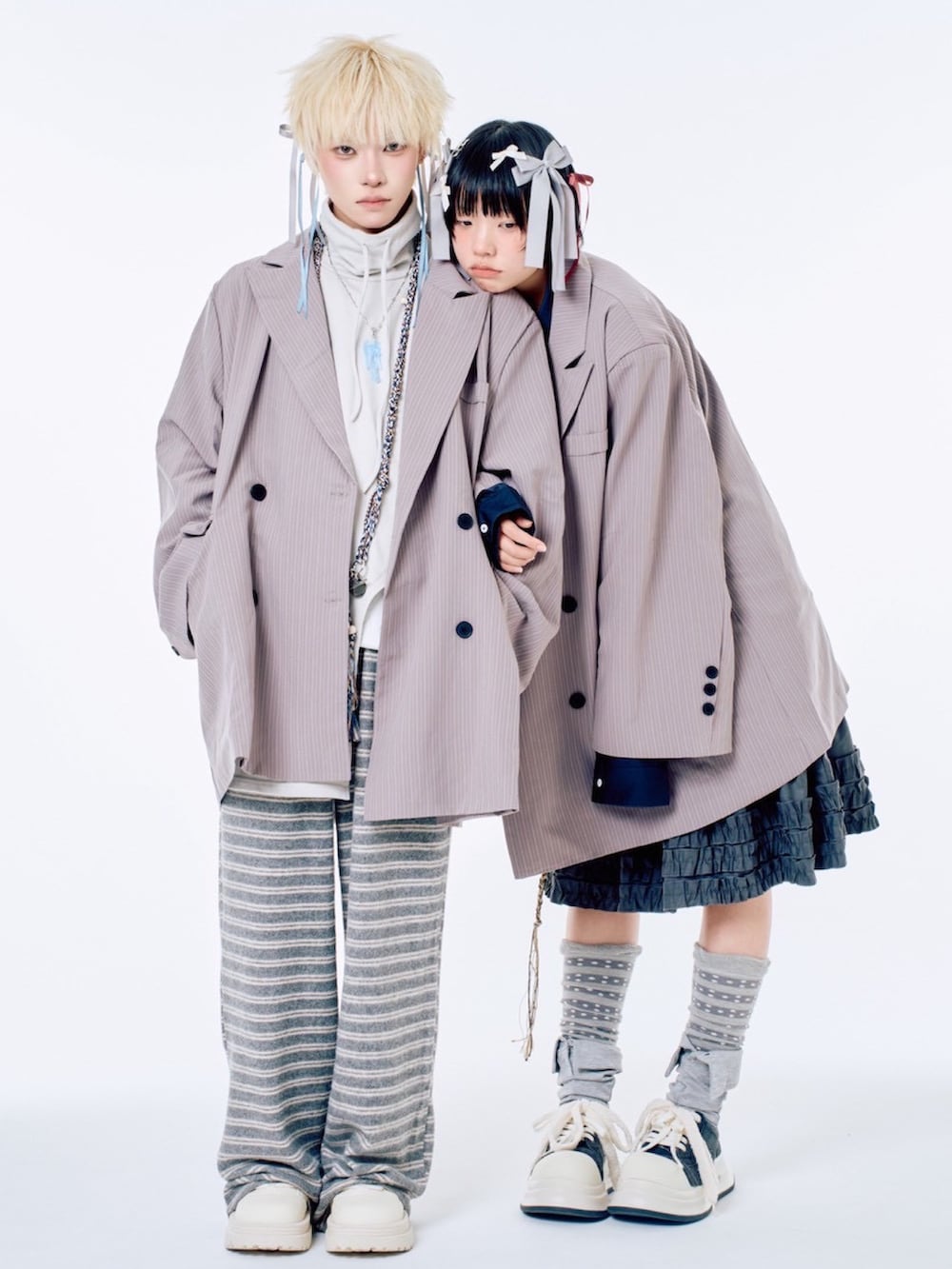 グレー系のスウェットパンツ、ブラック系のスカート、グレー系のテーラードジャケットを着用したレディースの春コーディネートの2枚目の写真