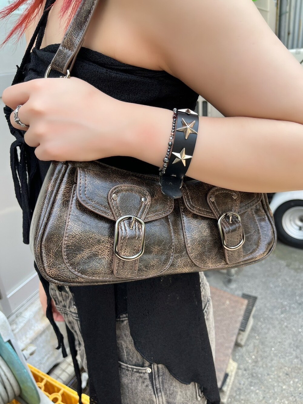 ベージュ系のデニムパンツ、ブラック系のチューブトップ、ブラウン系のショルダーバッグを着用したレディースの夏コーディネートの3枚目の写真