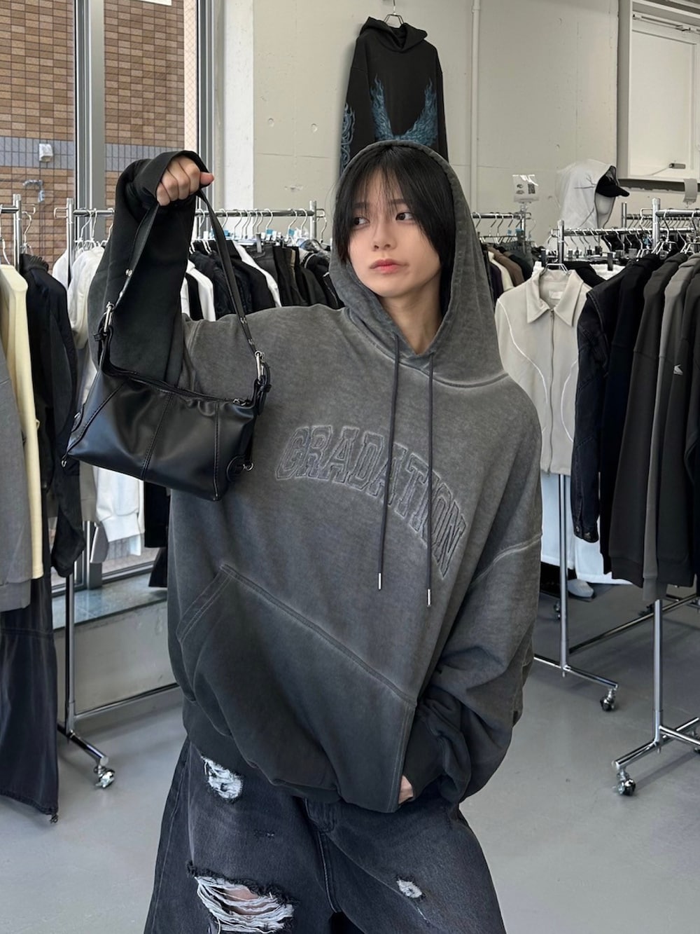 グレー系のパーカー、ブラック系のブーツを着用したメンズの秋コーディネートの2枚目の写真