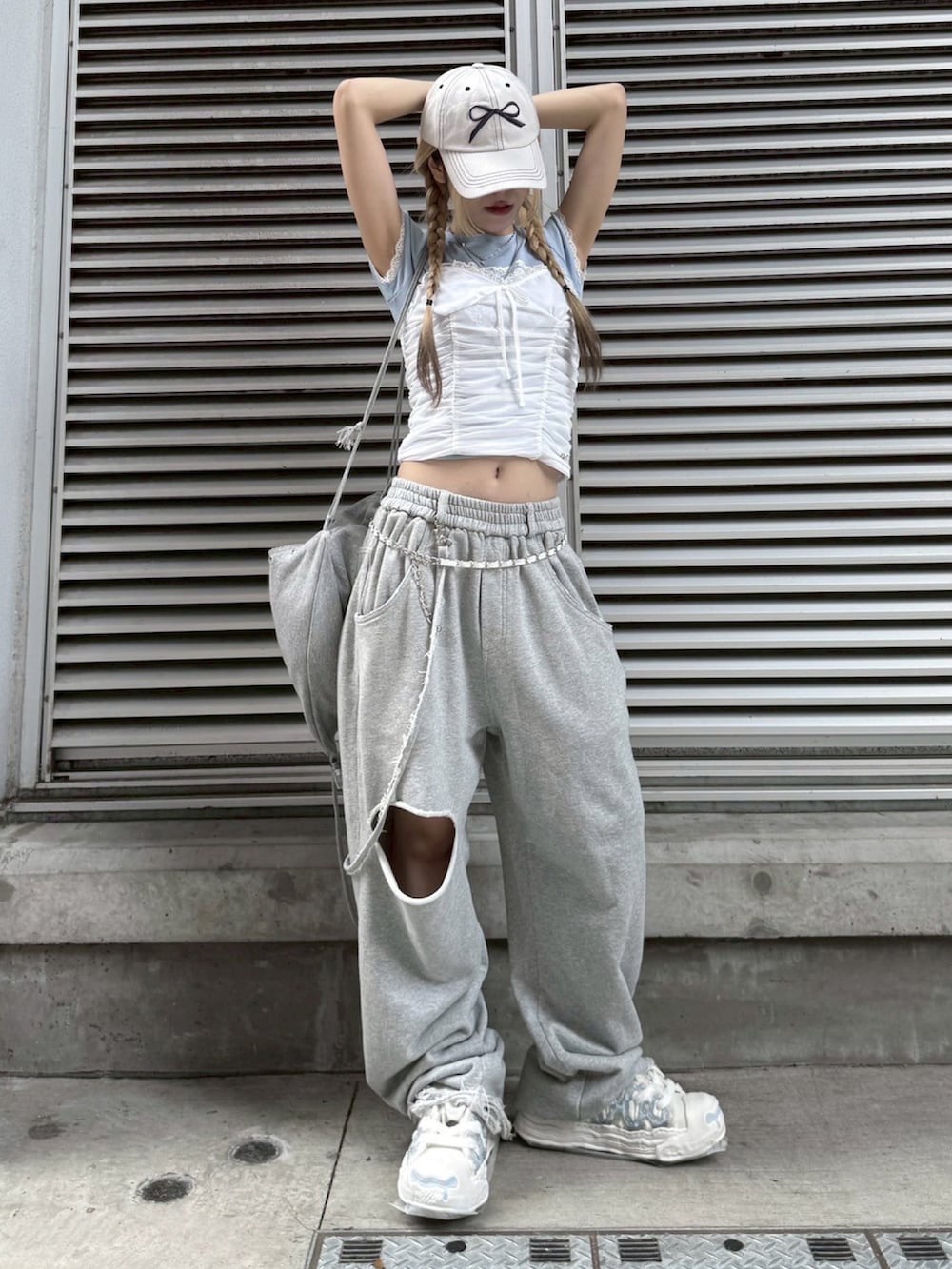 ブルー系のTシャツ/カットソー、ホワイト系のキャミソール、グレー系のスウェットパンツを着用したレディースの春コーディネートの2枚目の写真