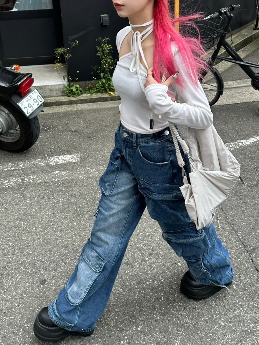 ホワイト系のカーディガン/ボレロ、ブルー系のデニムパンツを着用したレディースの春コーディネートの5枚目の写真