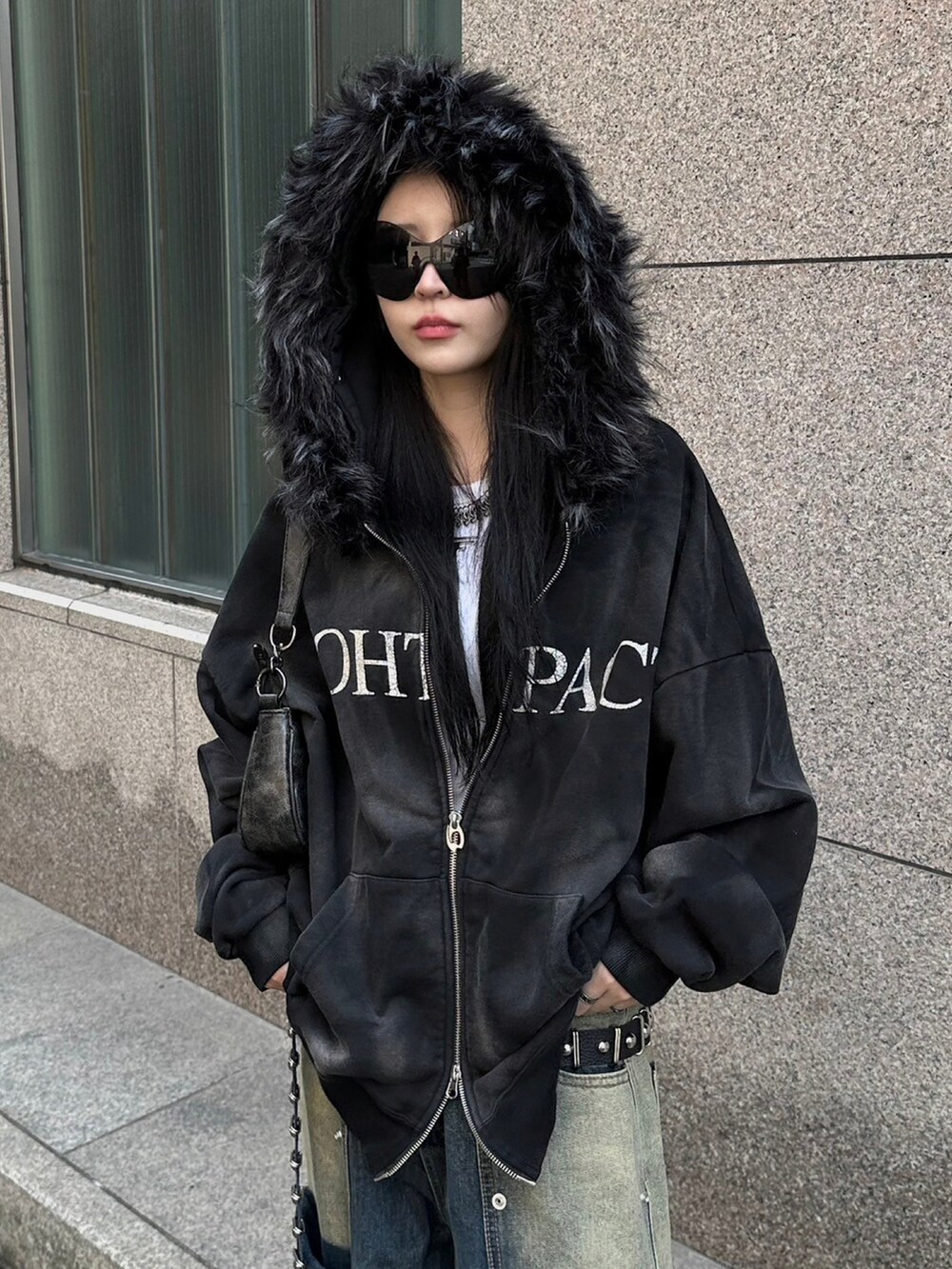 ブルー系のデニムパンツ、ブラック系のパーカー、ブラック系のショルダーバッグを着用したレディースの秋コーディネートの2枚目の写真