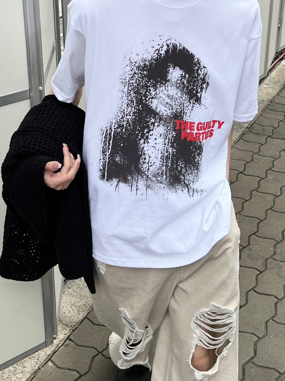 ブラック系のパーカー、ブラック系のスリッポン、ベージュ系のデニムパンツを着用したメンズの春コーディネートの3枚目の写真