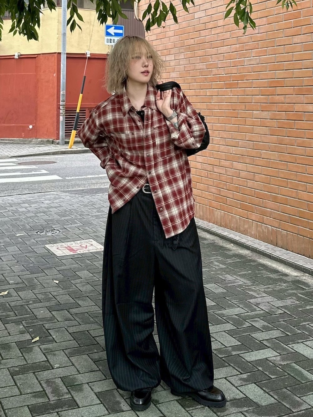 ブラック系のタンクトップ、ブラック系のトートバッグ、ブラック系のスラックスを着用したレディースの冬コーディネートの3枚目の写真