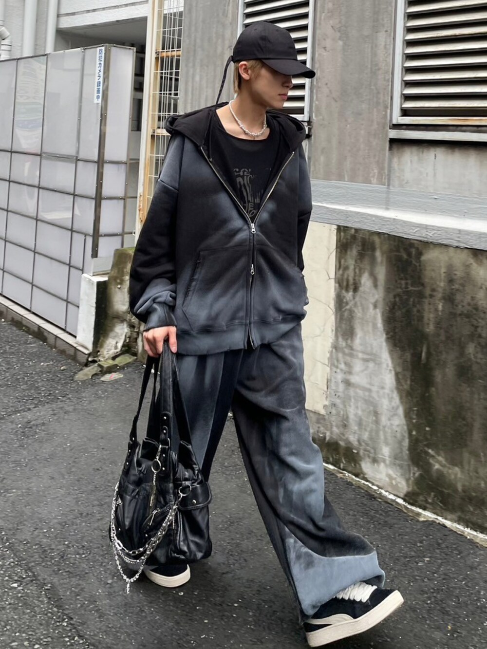 ブラック系のショルダーバッグ、ブラック系のパーカー、ブラック系のスウェットパンツを着用したメンズの秋コーディネートの2枚目の写真