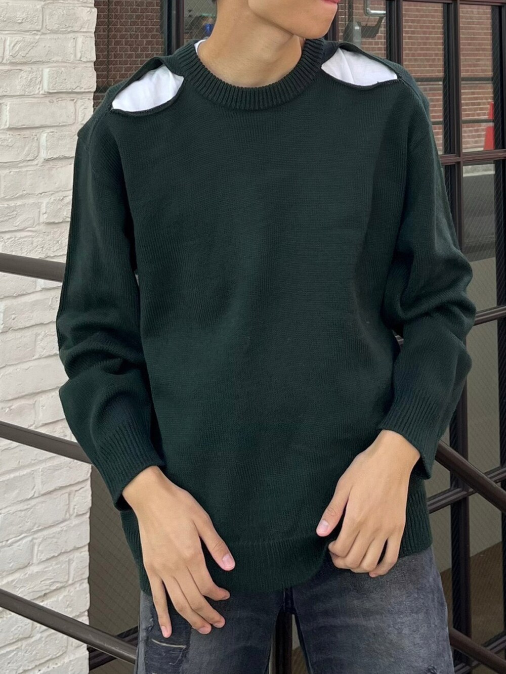 グリーン系のニット/セーター、ブラック系のデニムパンツを着用したメンズの秋コーディネートの3枚目の写真