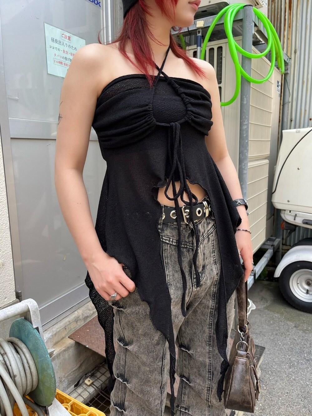 ベージュ系のデニムパンツ、ブラック系のチューブトップ、ブラウン系のショルダーバッグを着用したレディースの夏コーディネートの4枚目の写真