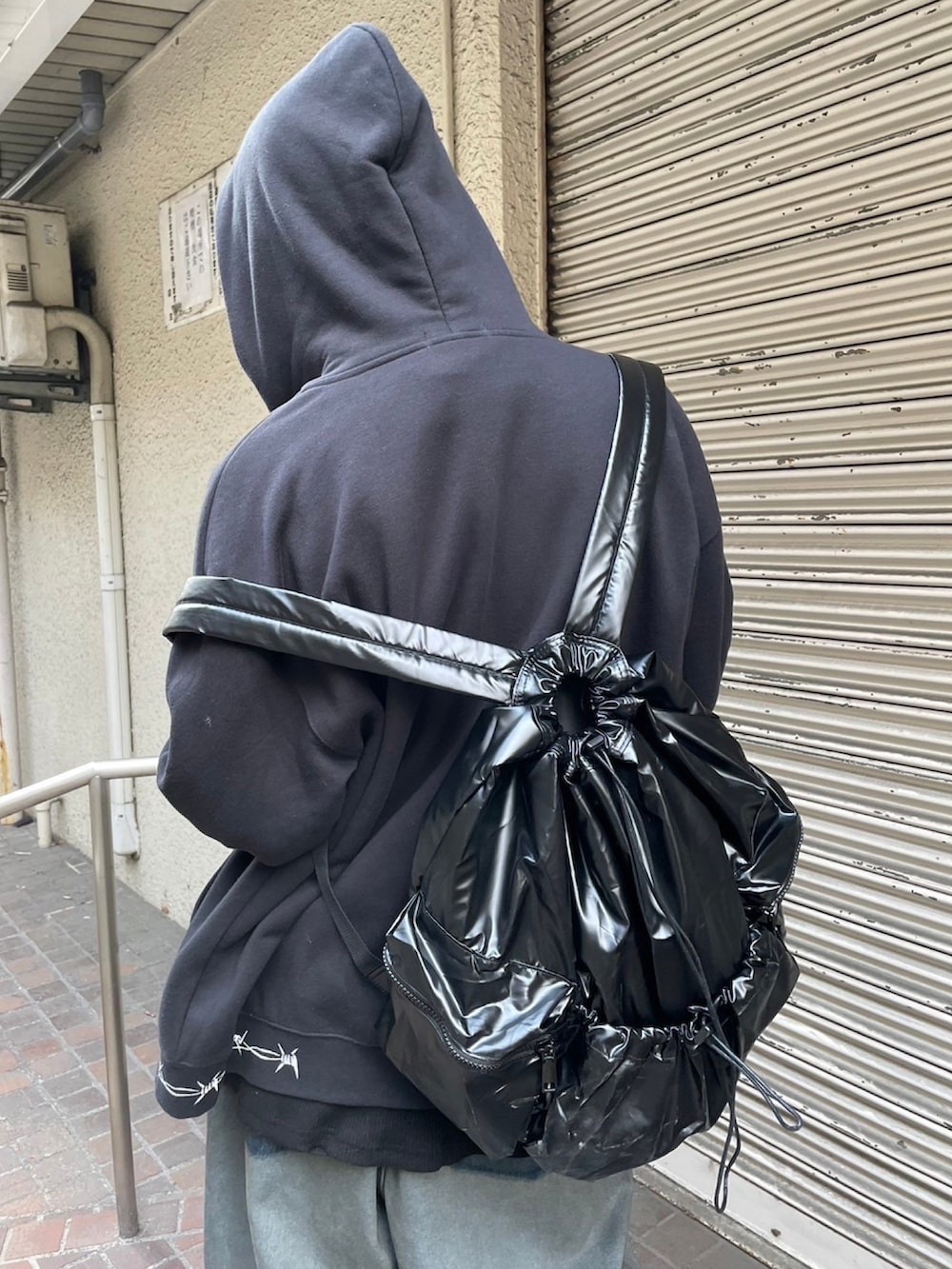 ブラック系のTシャツ/カットソー、ブラック系のパーカー、ブラック系のバックパック/リュックを着用したメンズの冬コーディネートの2枚目の写真