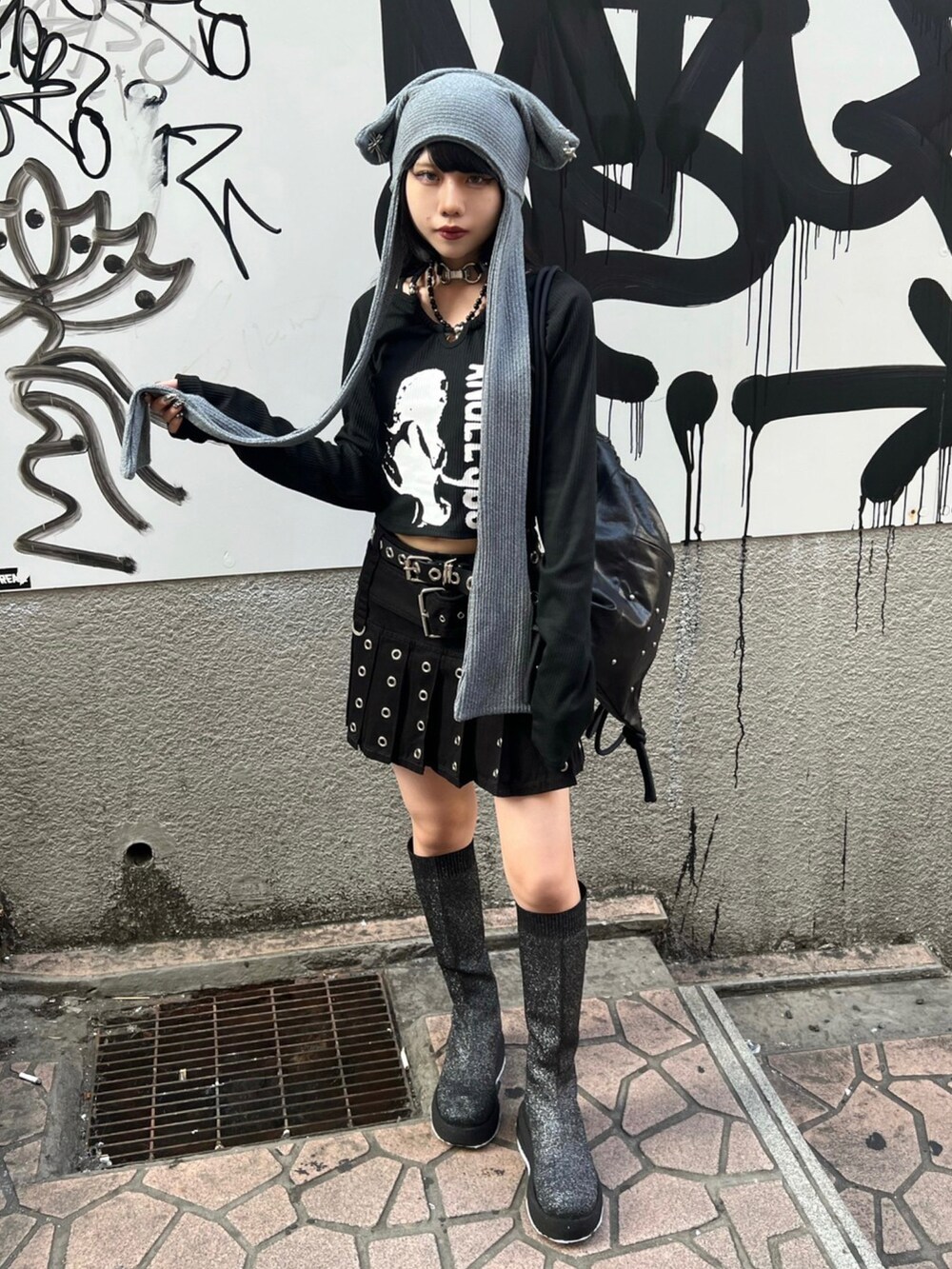 ブラック系のTシャツ/カットソー、ブラック系のバックパック/リュック、グレー系のニットキャップ/ビーニーを着用したレディースの秋コーディネートの2枚目の写真