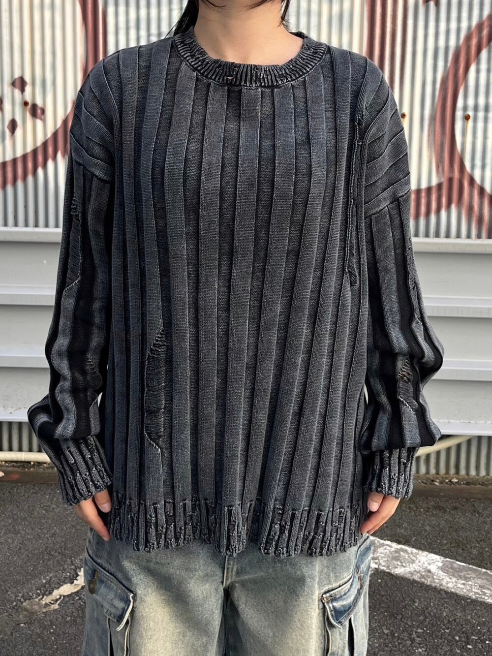 ブルー系のデニムパンツ、ブラック系のニット/セーター、ブラック系のパーカーを着用したレディースの秋コーディネートの5枚目の写真