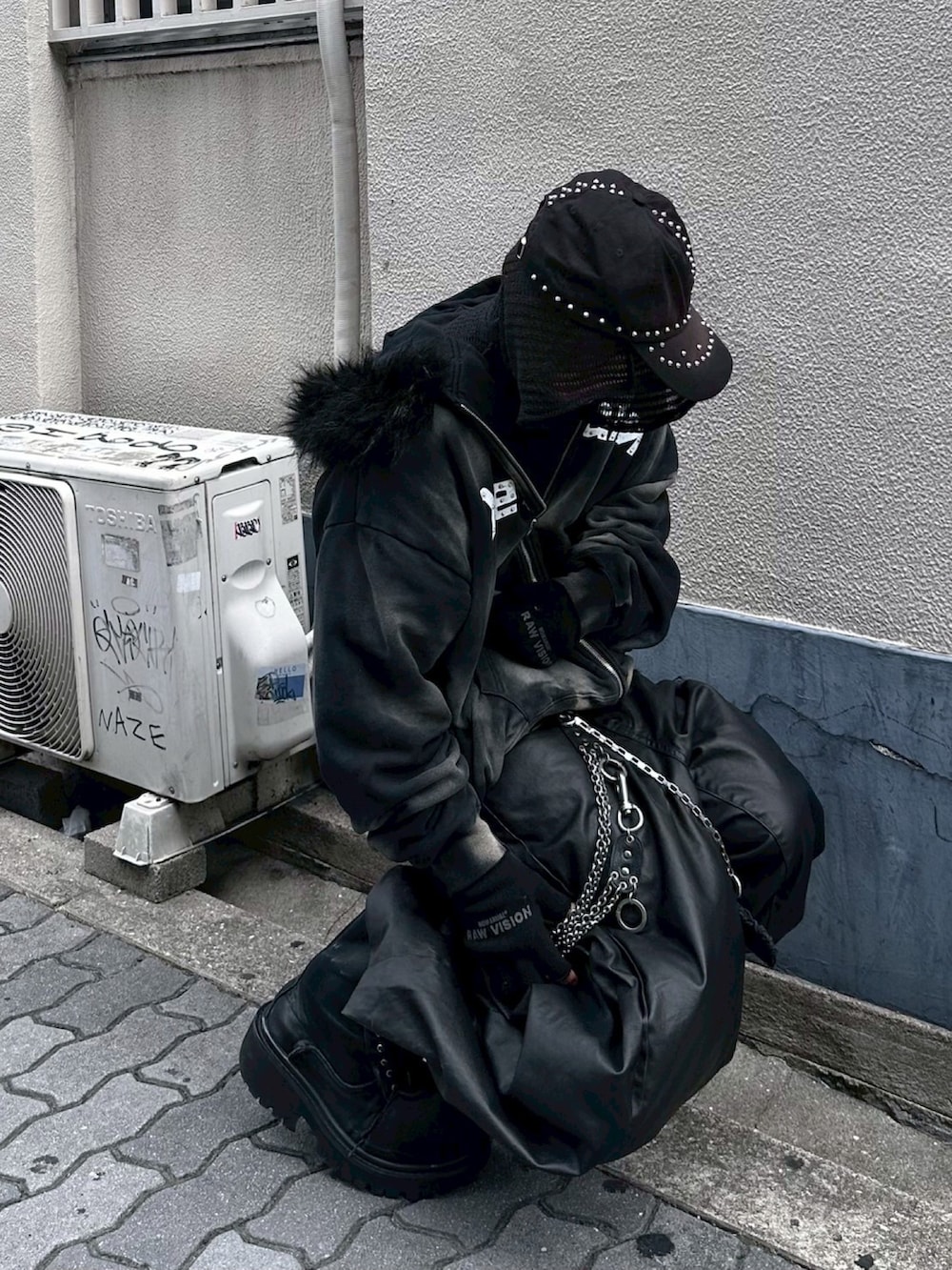 ブラック系のパーカー、ブラック系のデニムパンツ、ブラック系のキャップを着用したメンズの秋コーディネートの2枚目の写真