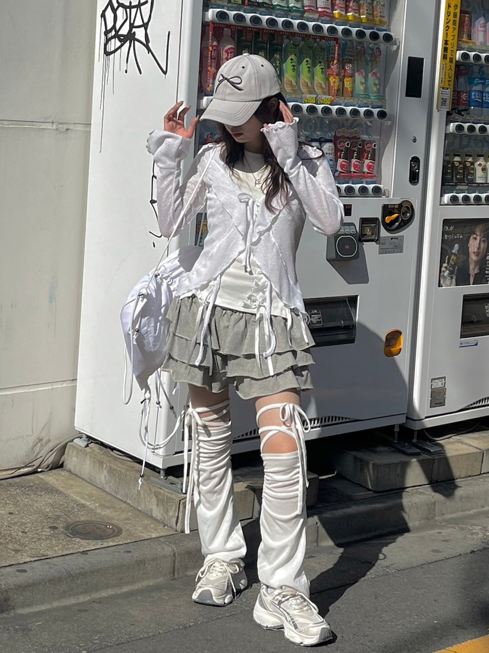 ホワイト系のタンクトップ、グレー系のスカート、ホワイト系のバックパック/リュックを着用したレディースの春コーディネートの5枚目の写真