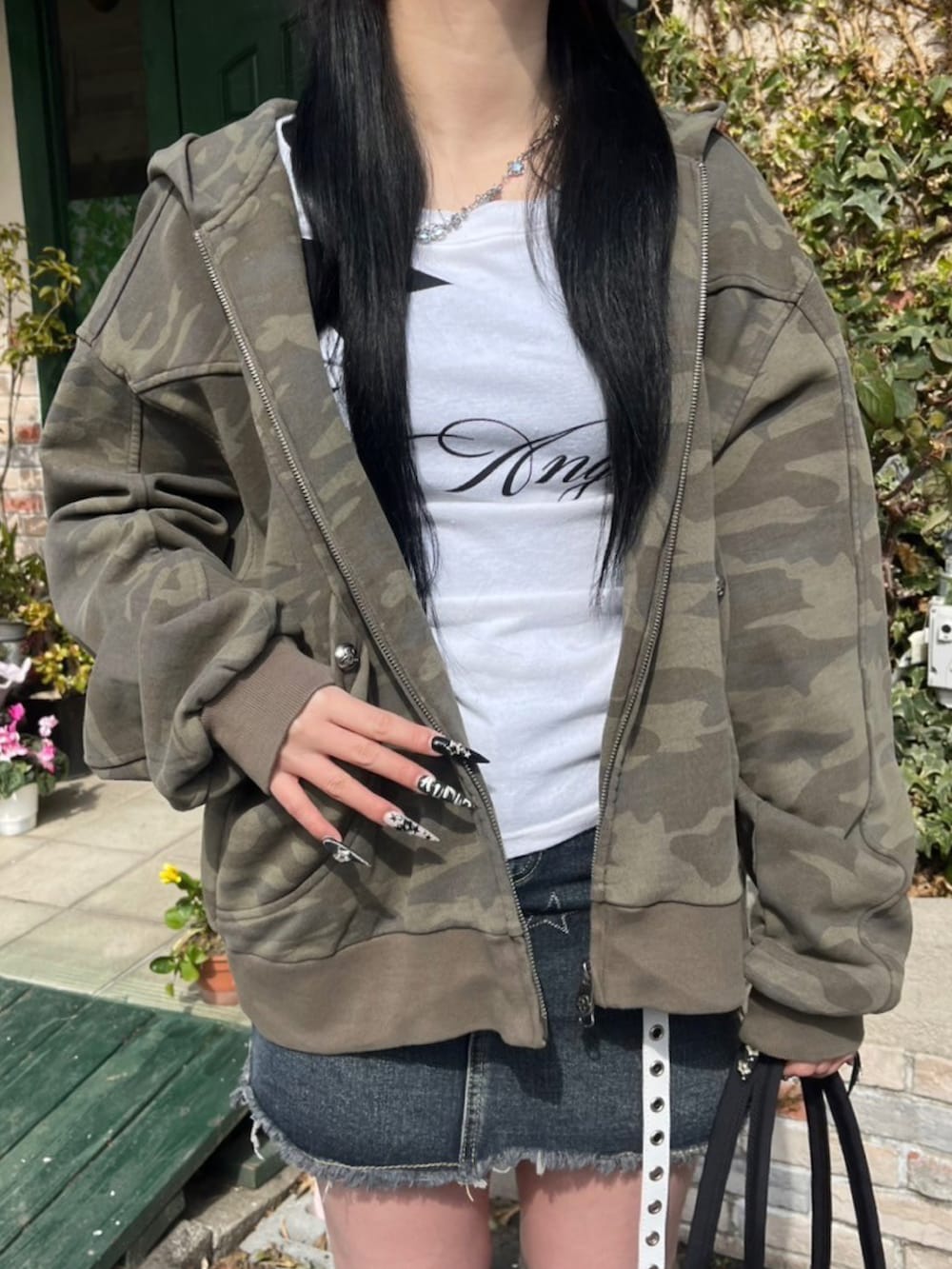 ホワイト系のTシャツ/カットソー、ブラック系のハンドバッグ、ベージュ系のレッグウォーマーを着用したレディースの冬コーディネートの3枚目の写真