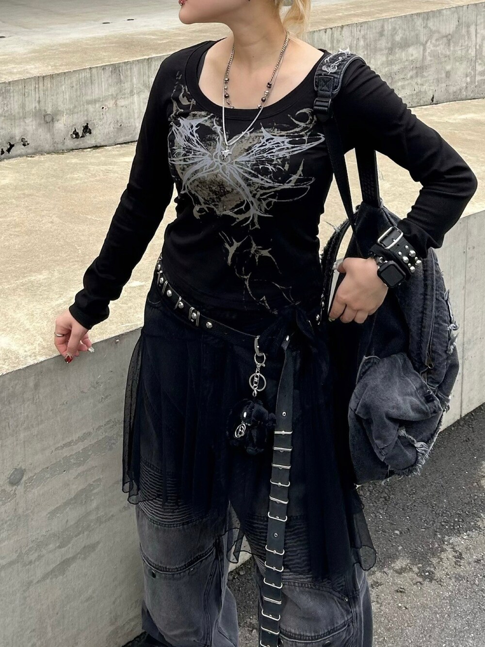 ブラック系のTシャツ/カットソー、ブラック系のデニムパンツ、ブラック系のベルトを着用したレディースの秋コーディネートの2枚目の写真