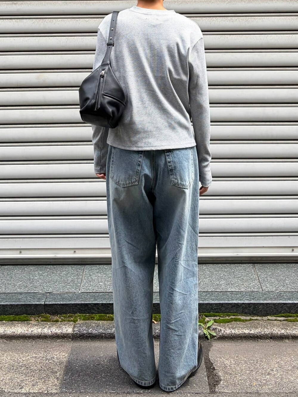 グレー系のTシャツ/カットソー、ブラック系のショルダーバッグ、ブルー系のデニムパンツを着用したメンズの秋コーディネートの4枚目の写真