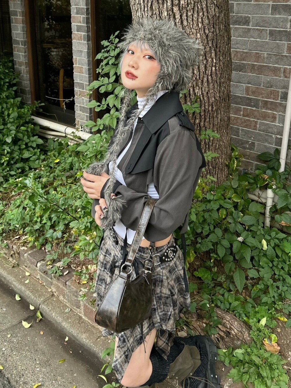 ブラウン系のショルダーバッグ、ブラック系のトレンチコート、グレー系のニットキャップ/ビーニーを着用したレディースの秋コーディネートの3枚目の写真