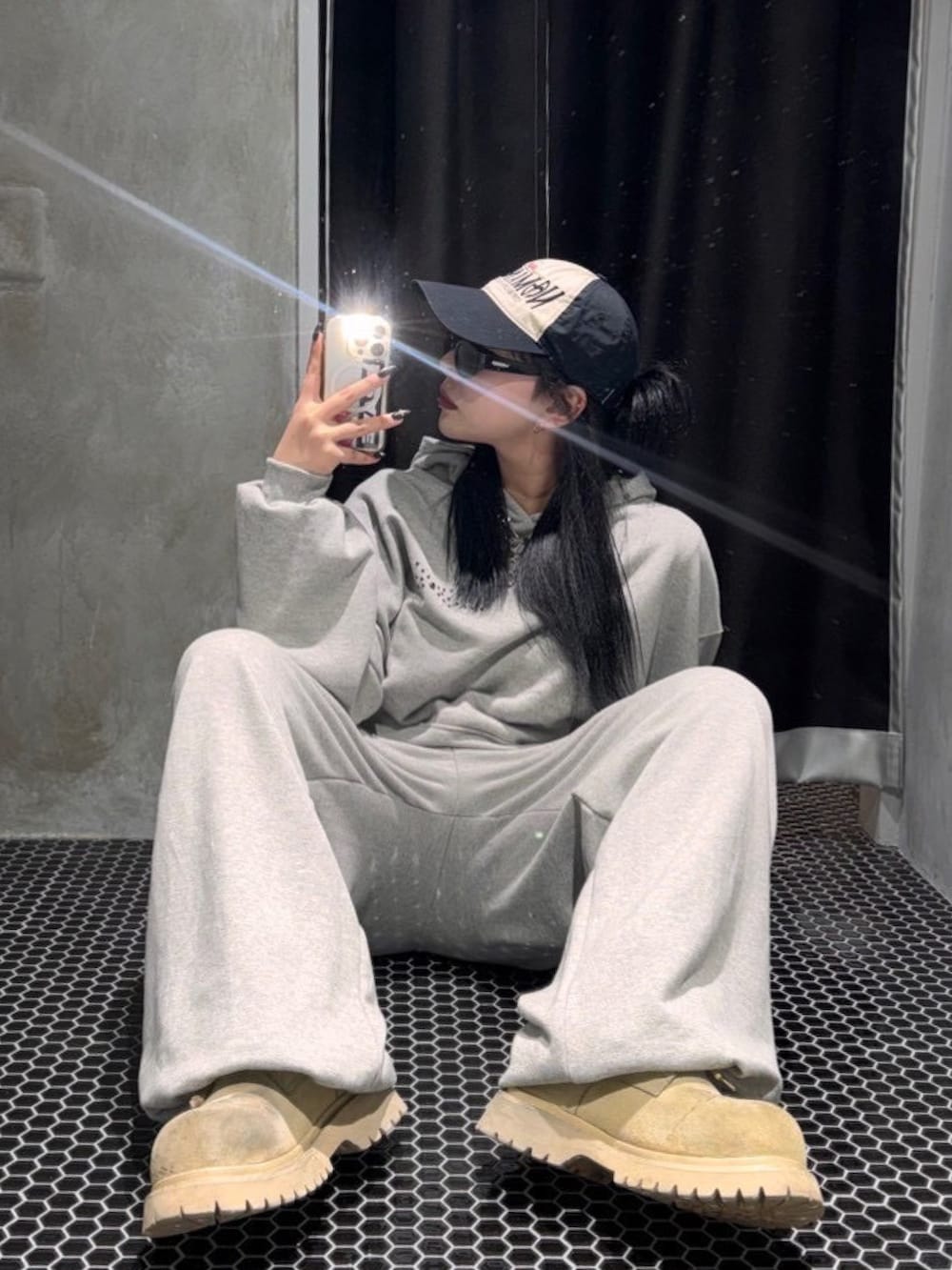 グレー系のパーカー、グレー系のスウェットパンツを着用したレディースの春コーディネートの3枚目の写真