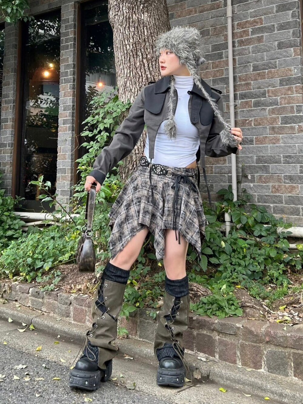 ブラウン系のショルダーバッグ、ブラック系のトレンチコート、グレー系のニットキャップ/ビーニーを着用したレディースの秋コーディネートの5枚目の写真