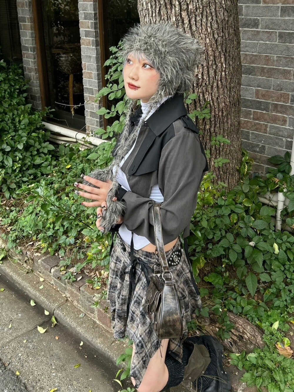 ブラウン系のショルダーバッグ、ブラック系のトレンチコート、グレー系のニットキャップ/ビーニーを着用したレディースの秋コーディネートの4枚目の写真