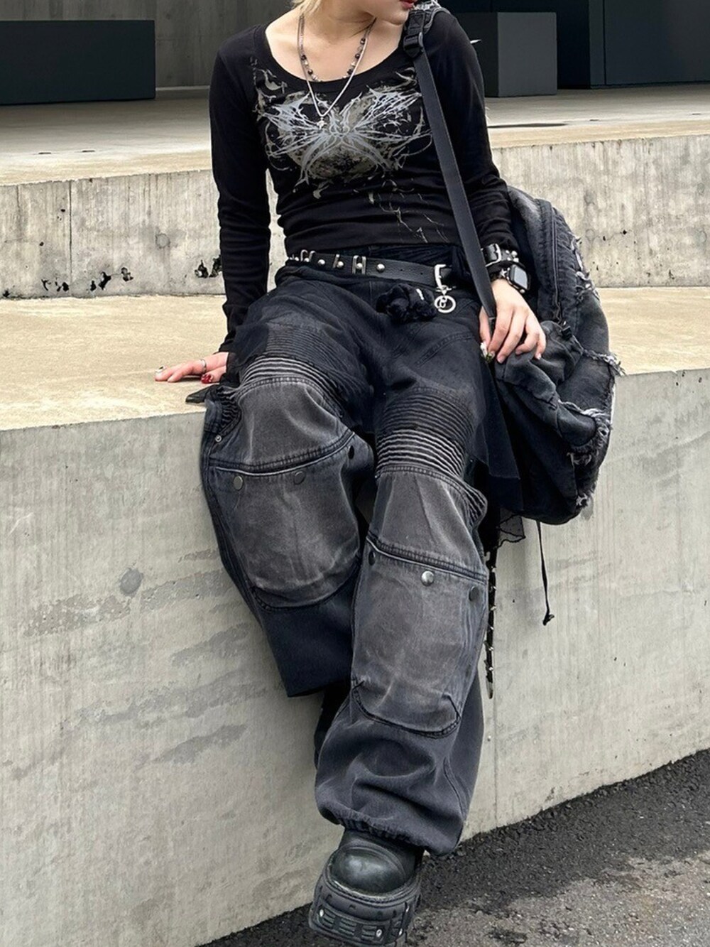 ブラック系のTシャツ/カットソー、ブラック系のデニムパンツ、ブラック系のベルトを着用したレディースの秋コーディネートの4枚目の写真