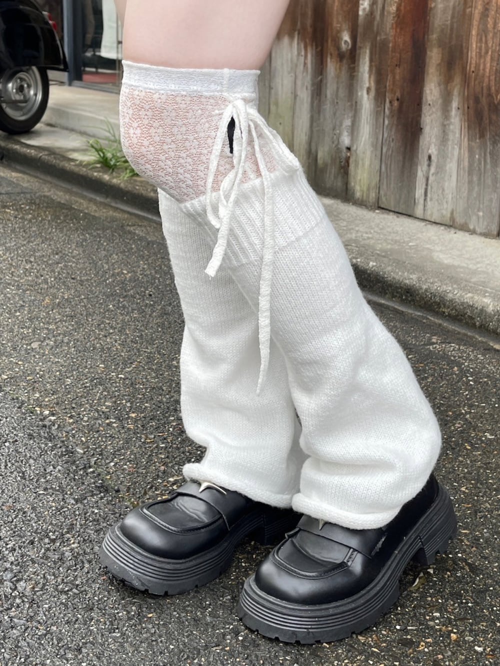 ブラック系のハンドバッグ、ホワイト系のシャツ/ブラウス、ホワイト系のレッグウォーマーを着用したレディースの夏コーディネートの3枚目の写真