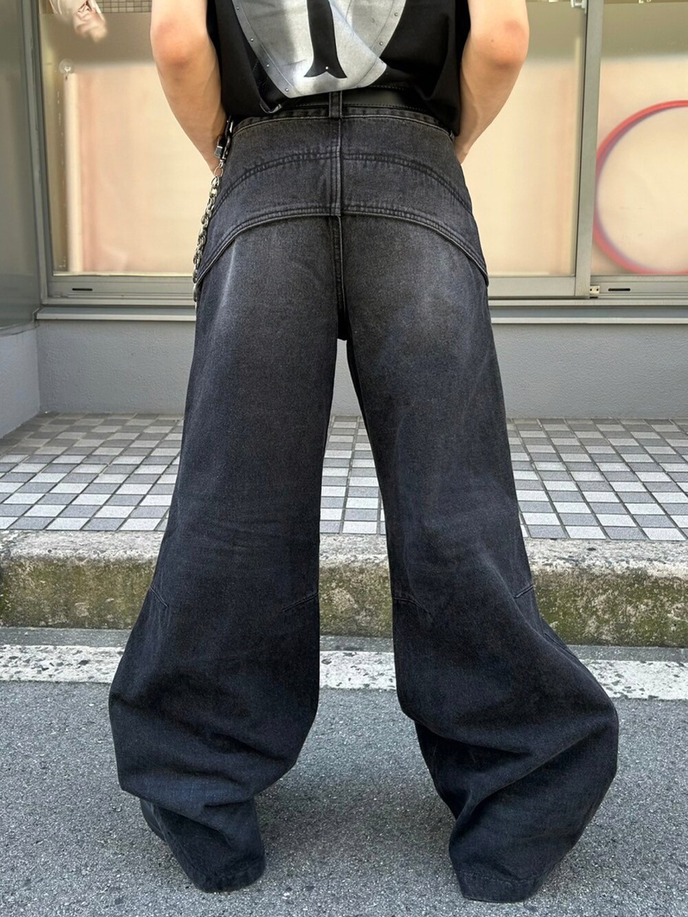 ブラック系のデニムパンツ、ブラック系のスリッポン、ブラック系のキャップを着用したメンズの夏コーディネートの4枚目の写真