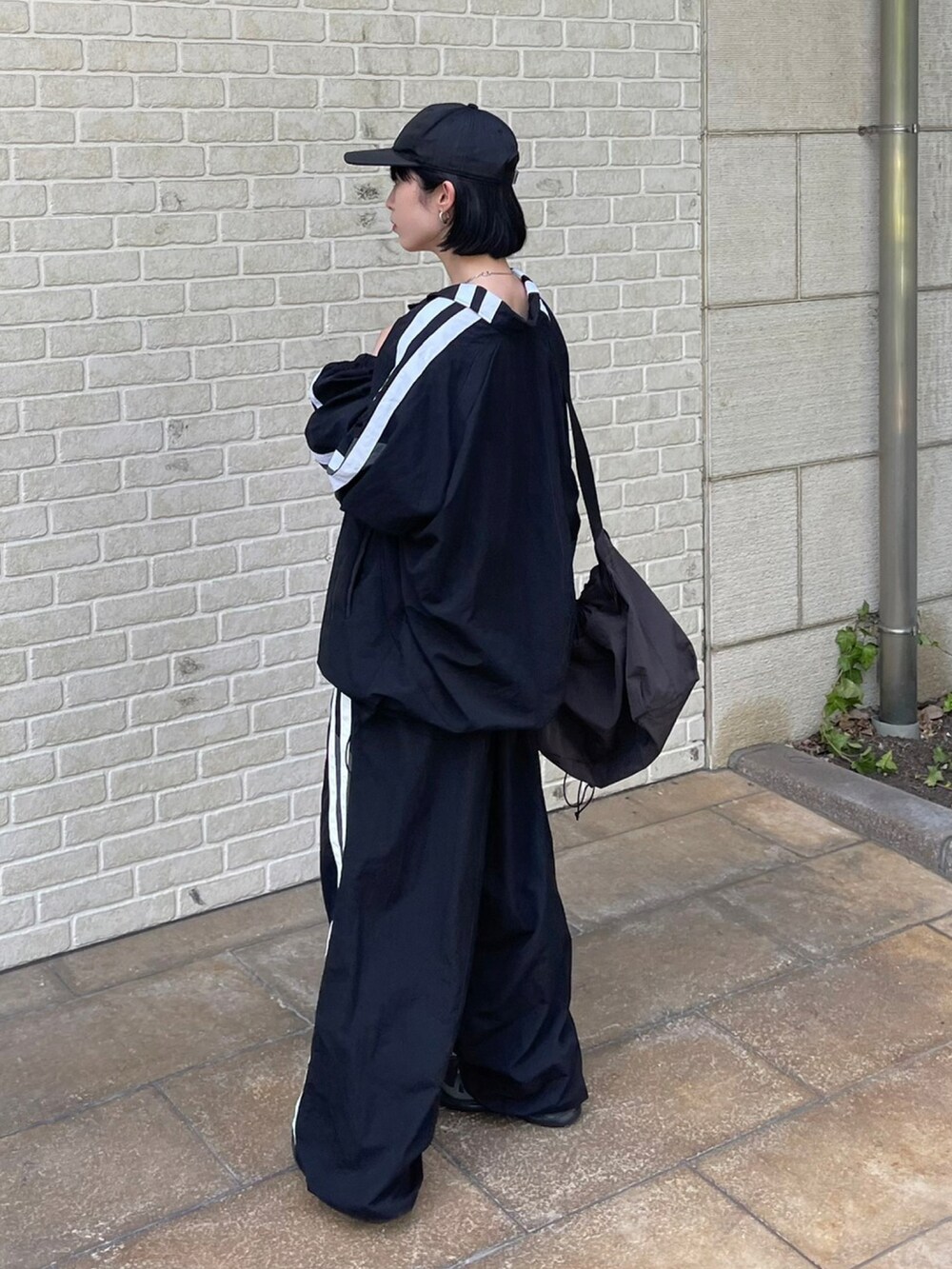 ブラック系のカーゴパンツ、ブラック系のブルゾンを着用したレディースの夏コーディネートの3枚目の写真