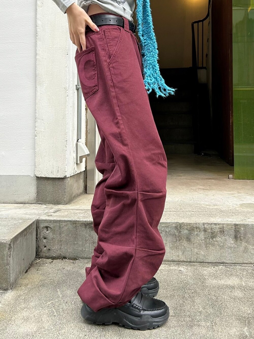 レッド系のデニムパンツを着用したレディースの秋コーディネートの4枚目の写真