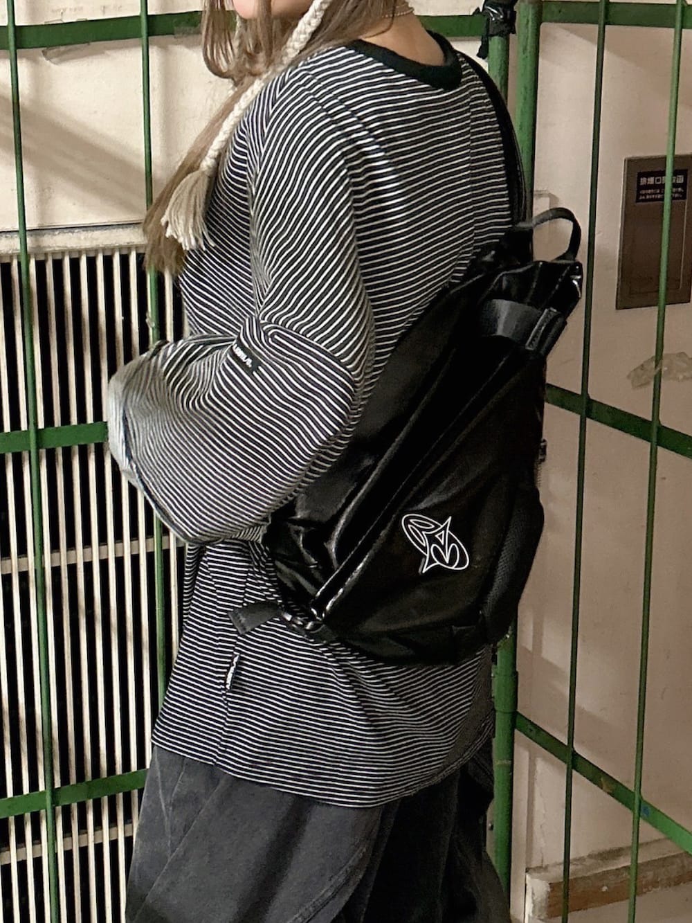 ブラック系のTシャツ/カットソー、ブラック系のデニムパンツ、ブラック系のショルダーバッグを着用したレディースの冬コーディネートの3枚目の写真