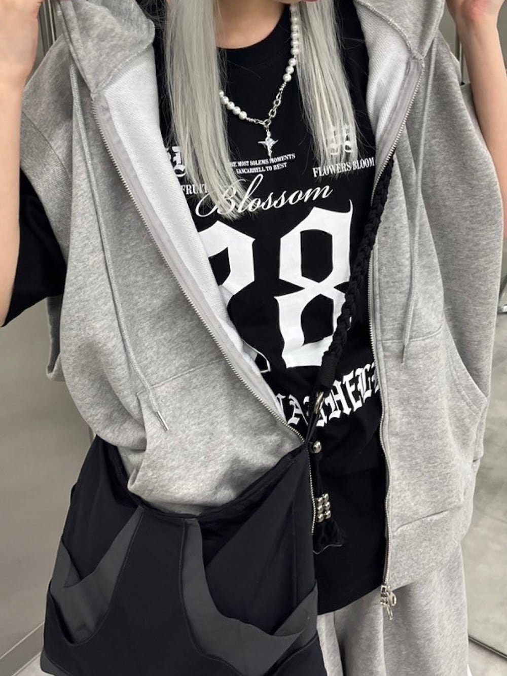 ブラック系のTシャツ/カットソー、ブラック系のショルダーバッグを着用したレディースの夏コーディネートの2枚目の写真