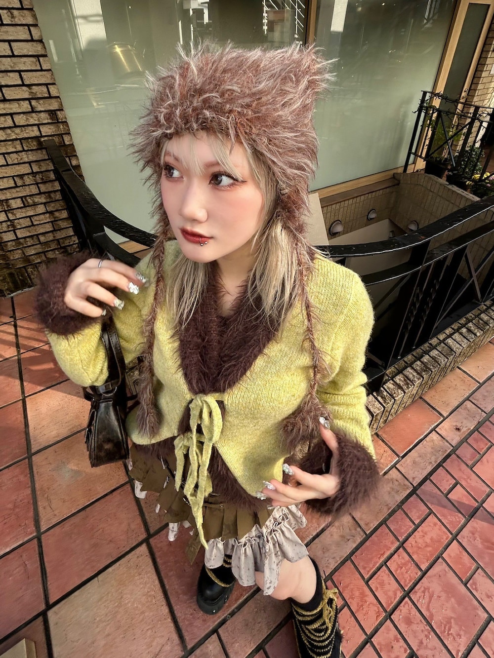 グリーン系のスカート、ブラウン系のショルダーバッグ、ブラウン系のニットキャップ/ビーニーを着用したレディースの冬コーディネートの4枚目の写真