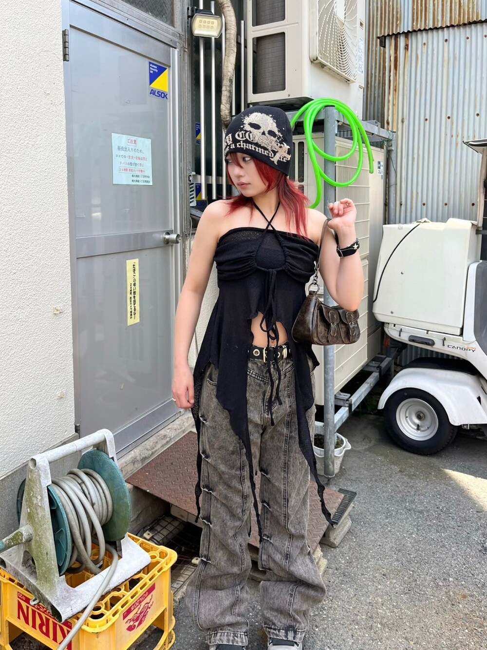 ベージュ系のデニムパンツ、ブラック系のチューブトップ、ブラウン系のショルダーバッグを着用したレディースの夏コーディネートの5枚目の写真