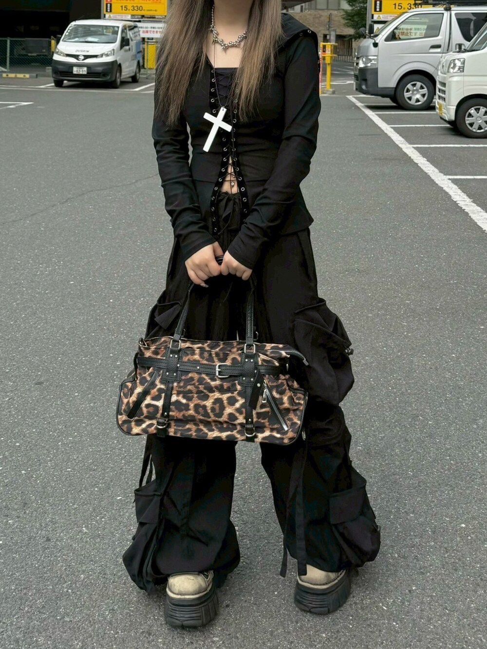 ブラウン系のショルダーバッグ、ブラック系のカーゴパンツ、ホワイト系のネックレスを着用したレディースの夏コーディネートの4枚目の写真