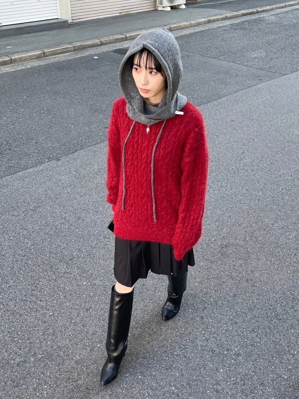 レッド系のニット/セーターを着用したレディースの冬コーディネートの2枚目の写真