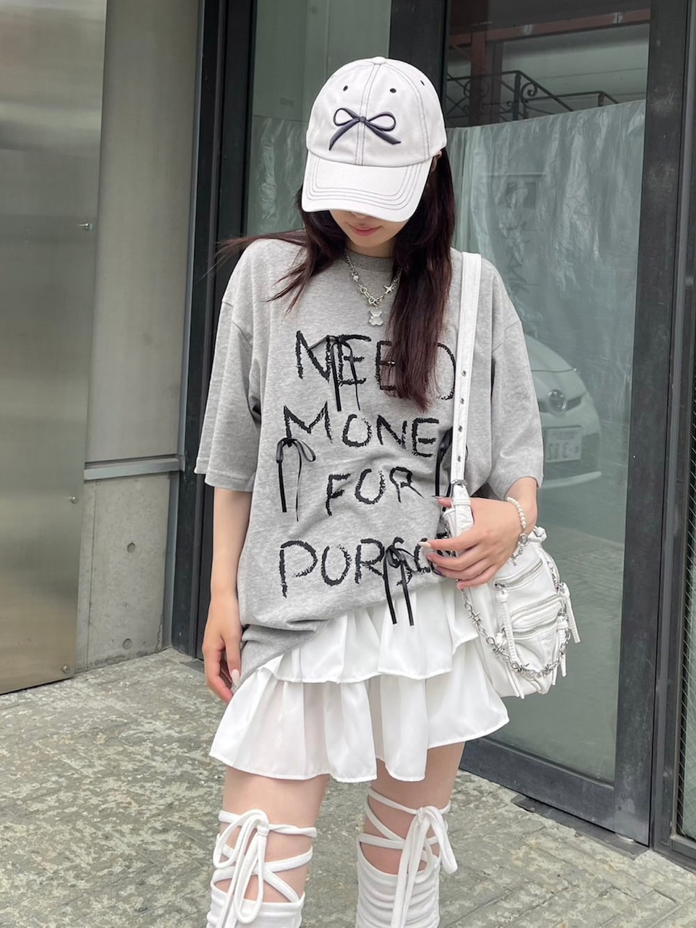 ホワイト系のショルダーバッグ、ホワイト系のキャップ、シルバー系のネックレスを着用したレディースの春コーディネートの4枚目の写真