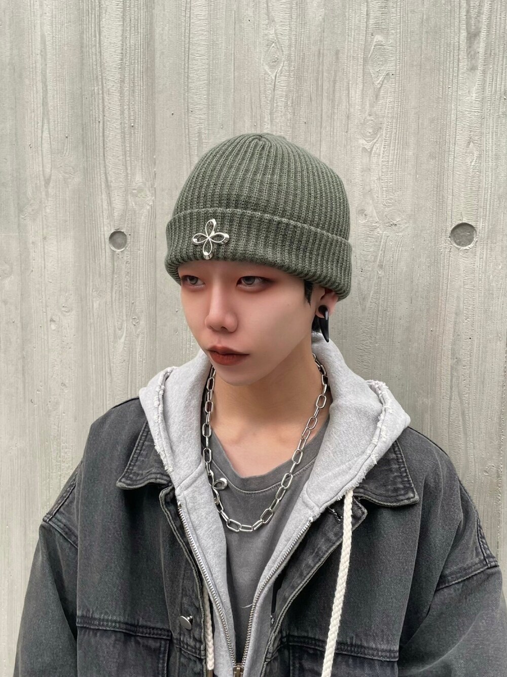 ブラック系のデニムジャケット、グレー系のパーカー、グリーン系のニットキャップ/ビーニーを着用したメンズの秋コーディネートの4枚目の写真