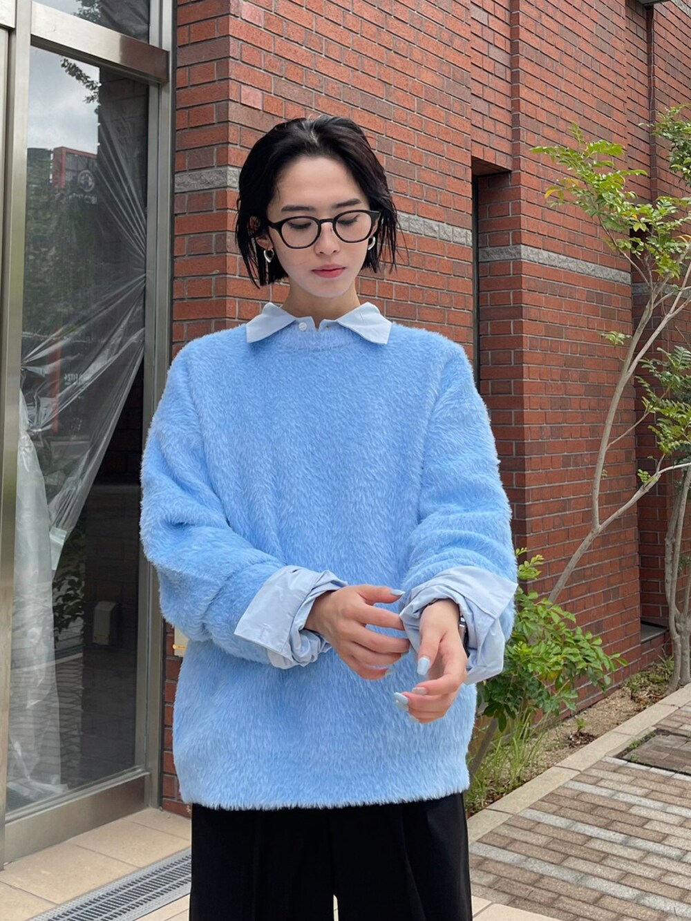 ブルー系のニット/セーターを着用したレディースの秋コーディネートの2枚目の写真