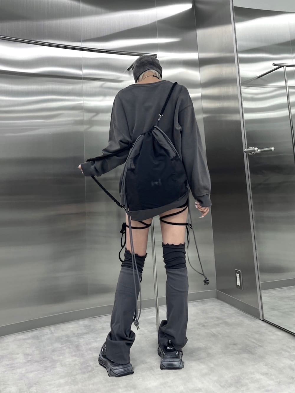 グレー系のスウェット、ブラック系のバックパック/リュック、パープル系のニットキャップ/ビーニーを着用したレディースの秋コーディネートの2枚目の写真