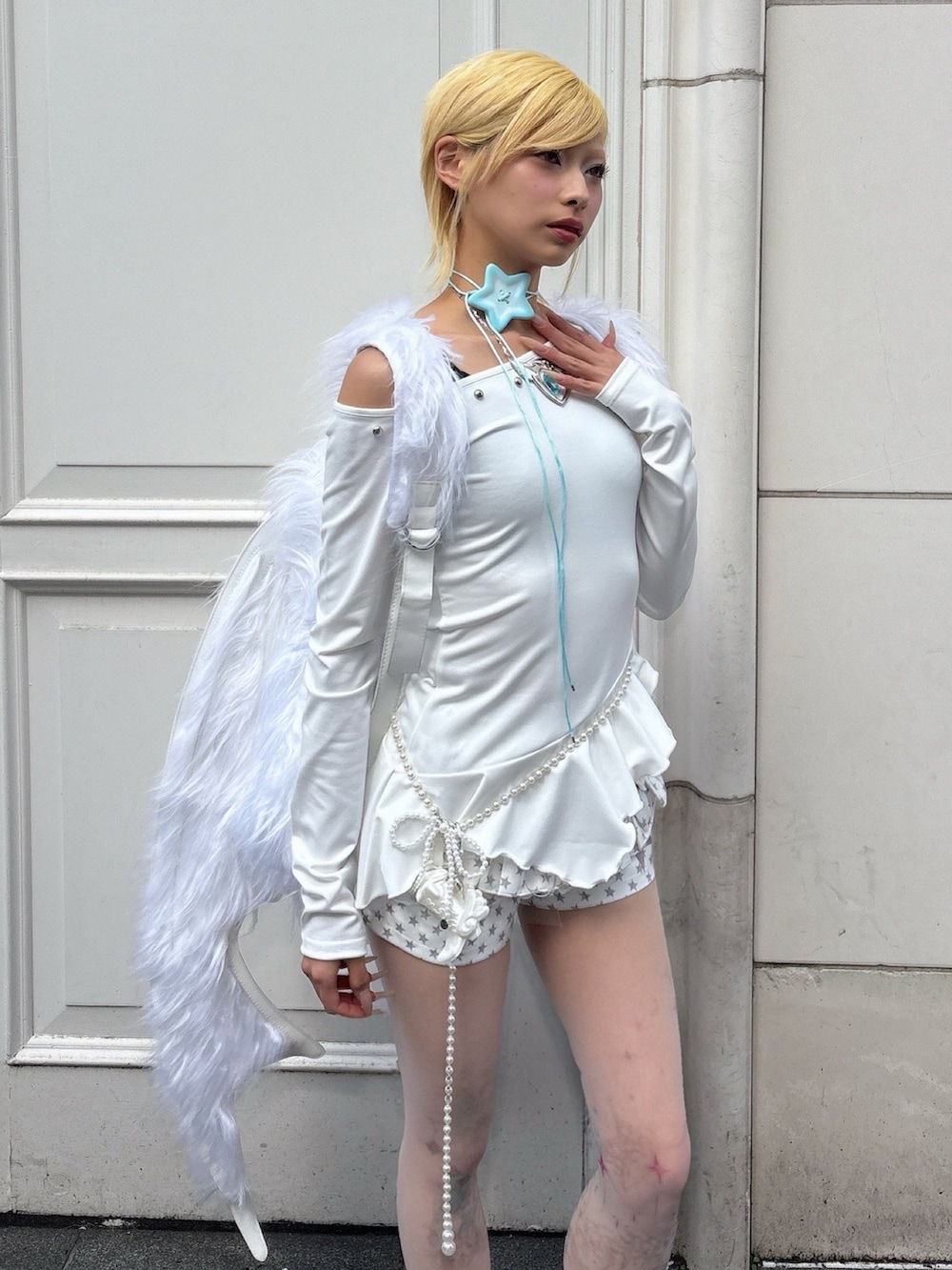 ホワイト系のバックパック/リュック、ホワイト系のその他パンツ、ベージュ系のタイツ/ストッキングを着用したレディースの春コーディネートの2枚目の写真