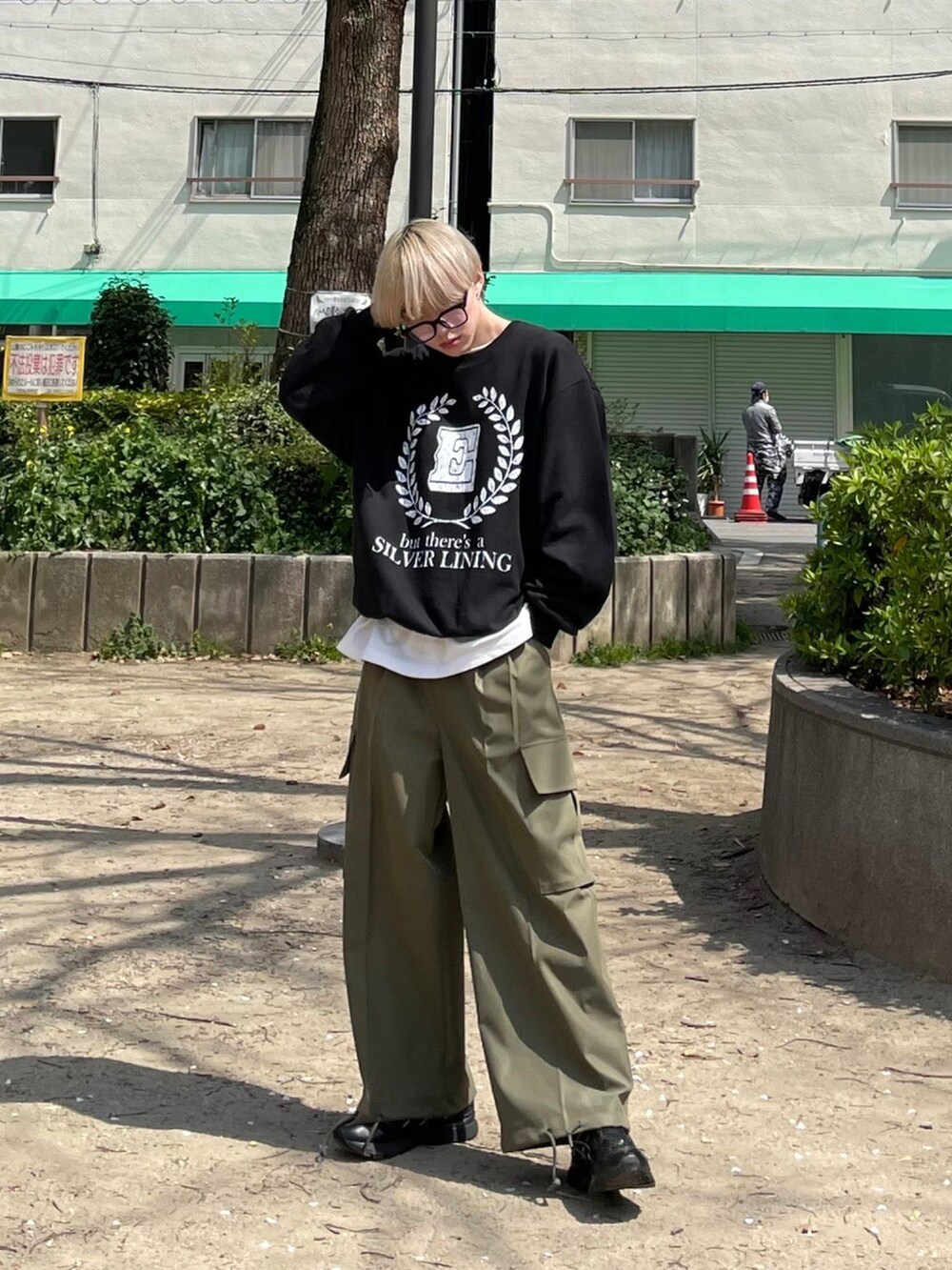 ブラック系のスウェット、グリーン系のカーゴパンツを着用したメンズの春コーディネートの3枚目の写真