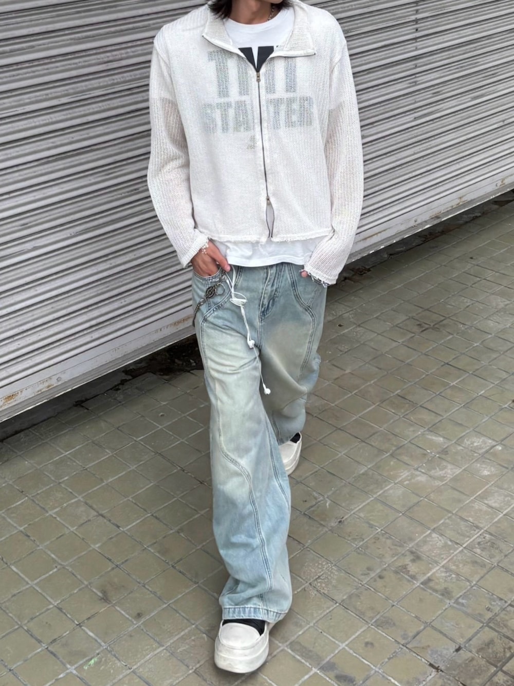 ホワイト系のカーディガン/ボレロ、ブルー系のデニムパンツ、ブラウン系のベルトを着用したメンズの秋コーディネートの3枚目の写真