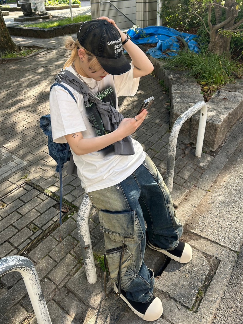 グレー系のパーカー、ブルー系のデニムパンツ、ブラック系のスニーカーを着用したレディースの春コーディネートの2枚目の写真