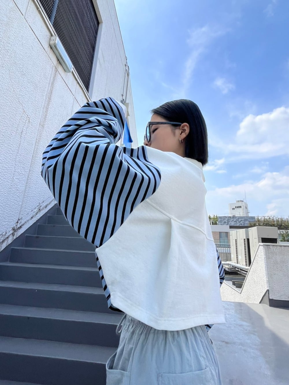 ブルー系のポロシャツ、ブルー系のサングラスを着用したレディースの夏コーディネートの3枚目の写真