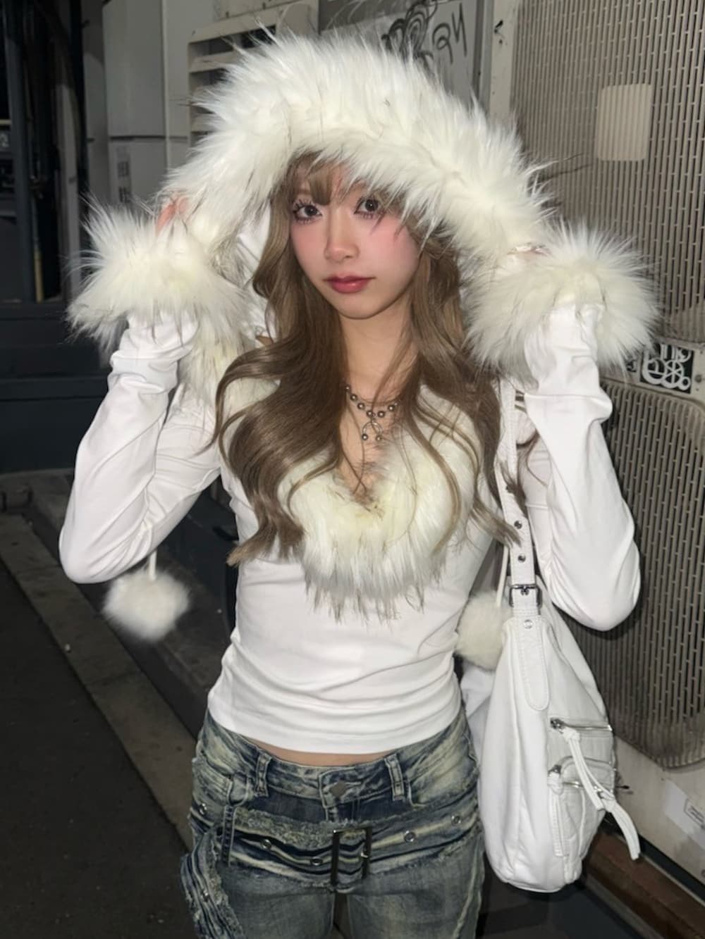 ホワイト系のショルダーバッグ、ブラック系のキーホルダーを着用したレディースの冬コーディネートの3枚目の写真